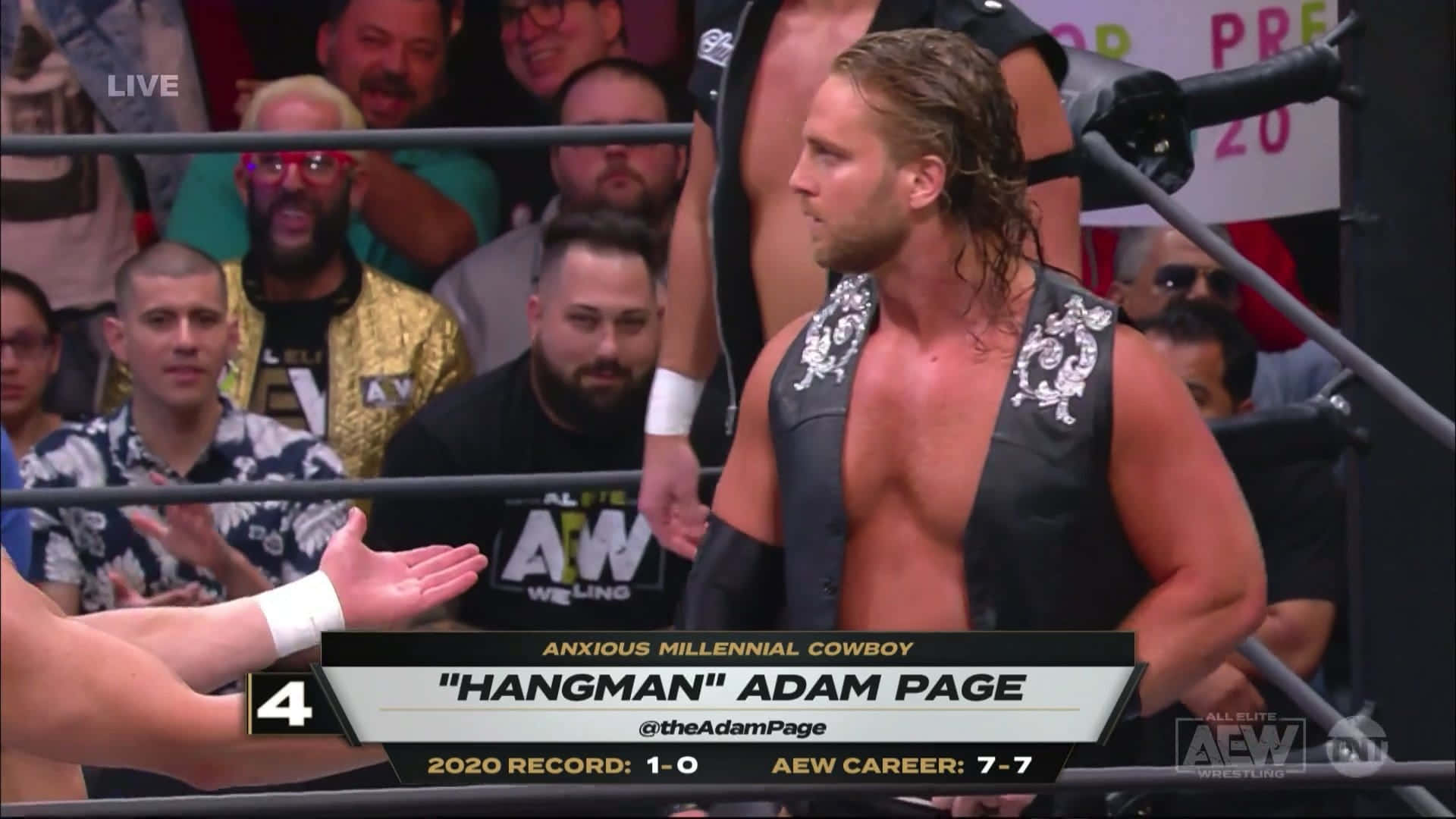 摔角手 Adam Page 在 AEW 比賽期間站在擂台上，觀眾觀看。