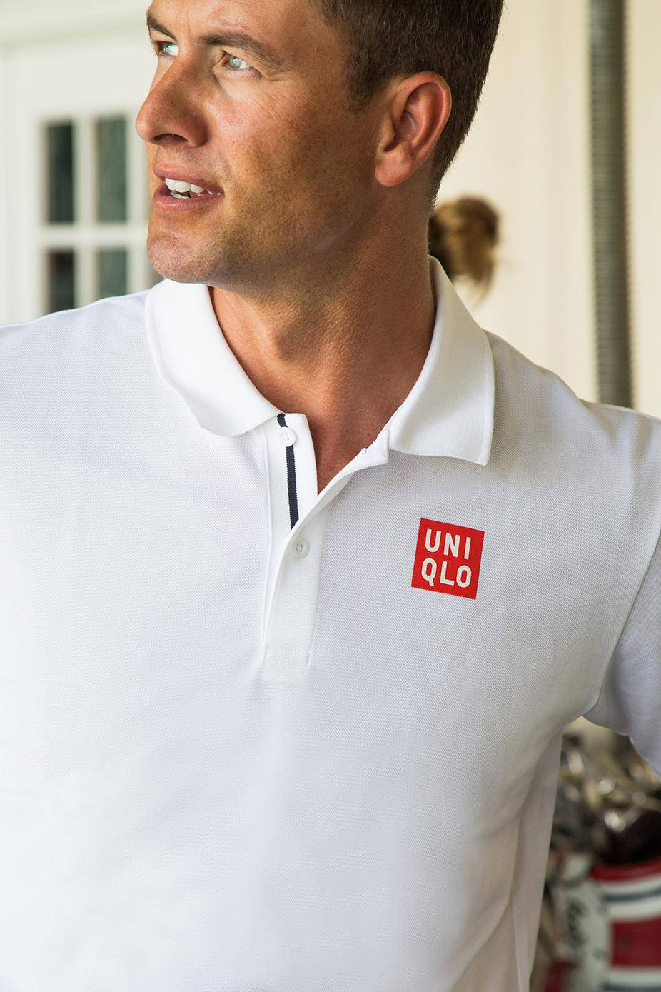 男子在室內穿著白色Uniqlo Polo衫