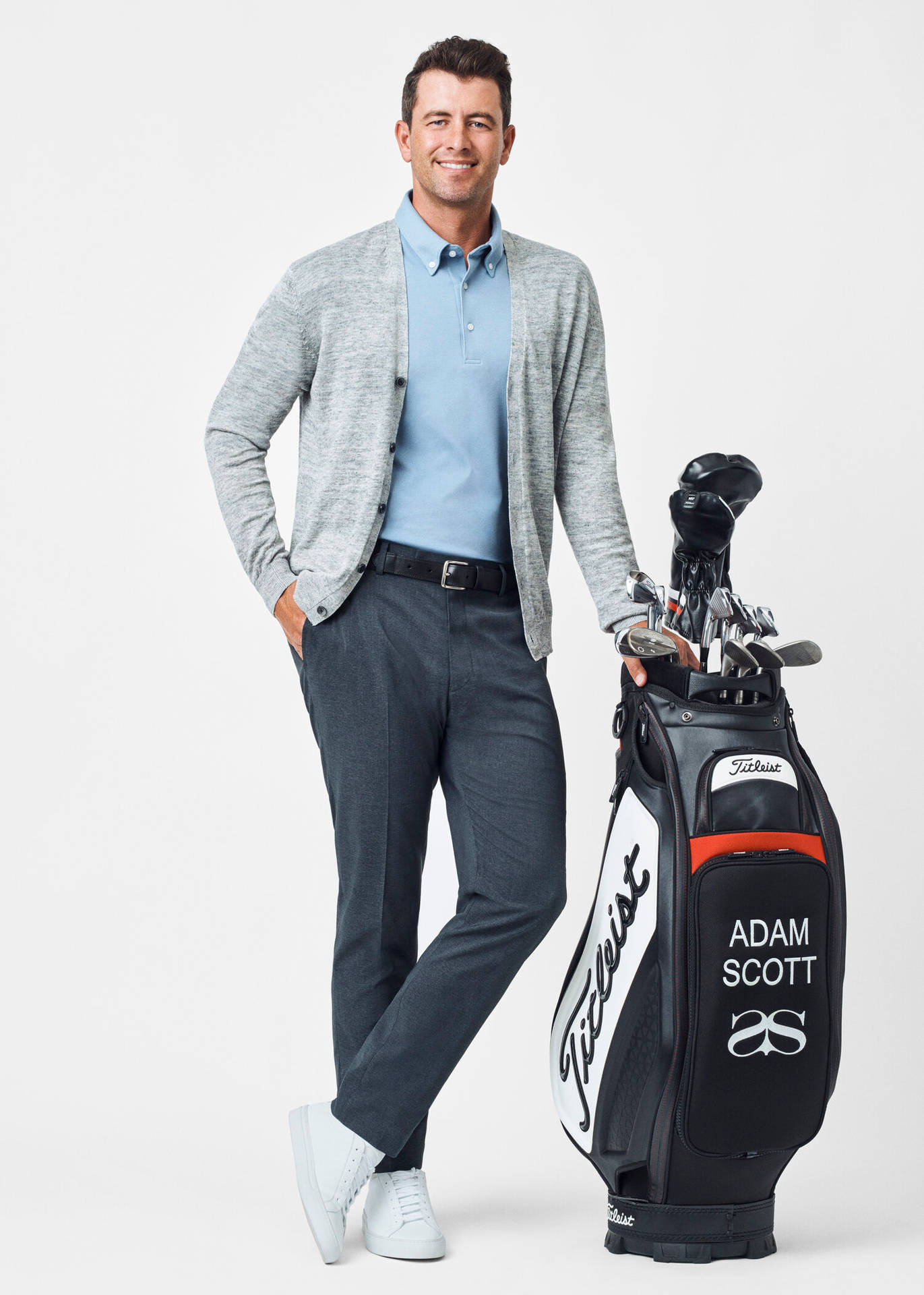 職業高爾夫球手Adam Scott在攝影棚中與他的高爾夫球袋合影。