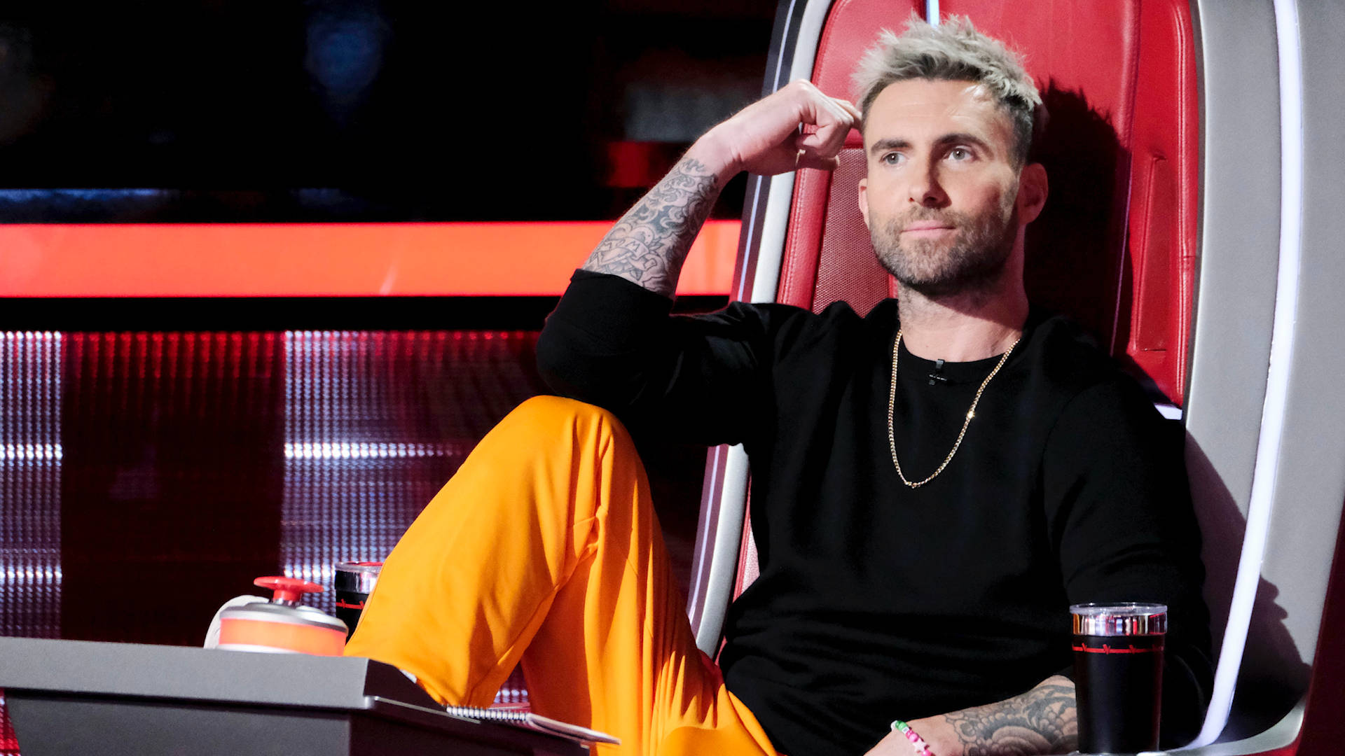 Adam Levine 坐在《The Voice》電視節目的紅色評判椅上。