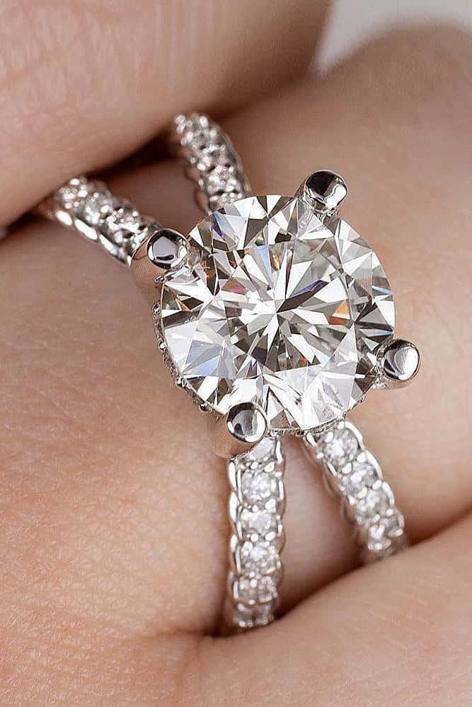 手戴著鑽石訂婚戒指和相配的結婚戒指。