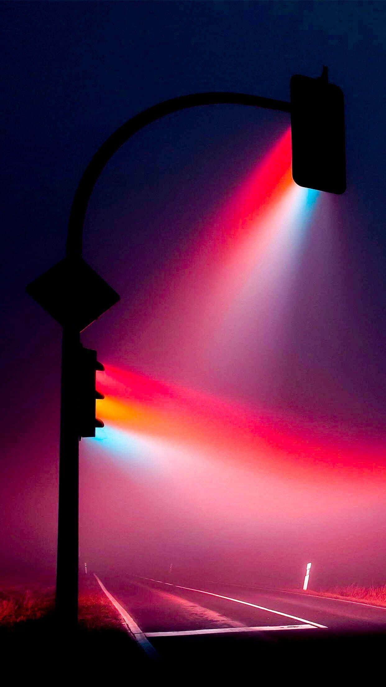 Fluorescent 桌布 壁紙 — 交通燈在夜晚黑暗空無一人的道路上，透過霧氣投射出鮮豔的紅色和藍色光束。