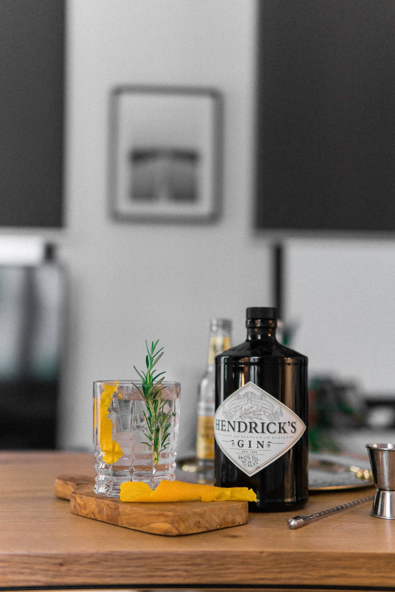 Hendrick's氈酒瓶和迷迭香柑橘雞尾酒在木板上。