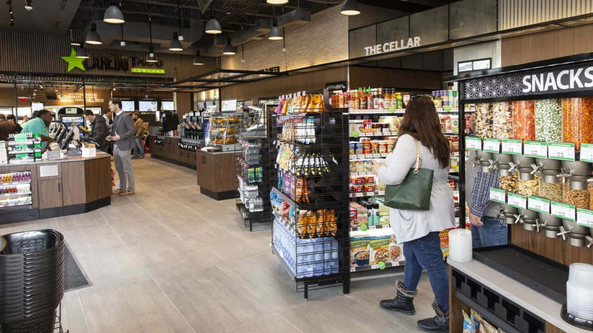 購物者在現代雜貨店瀏覽零食貨架和「The Cellar」區域。