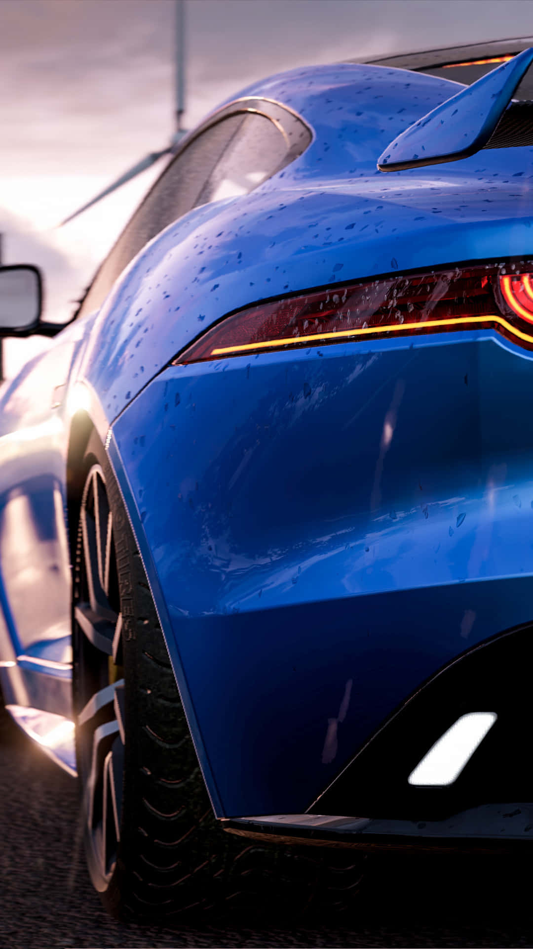 享受HD Project Cars 2的虛擬賽車體驗 壁紙 — 一輛亮面藍色跑車帶着雨滴，在柔和嘅黎明天空下閃閃發光，背景有風力發電機。