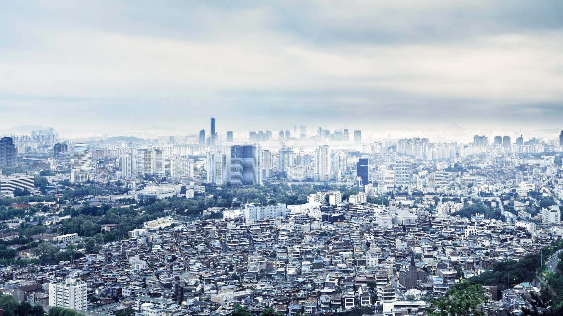 在多雲的天空下，一座擁有新舊建築的城市。