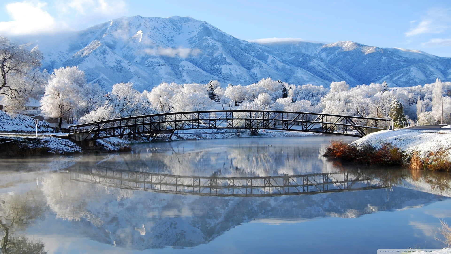 冬日河上雪橋與山巒倒影