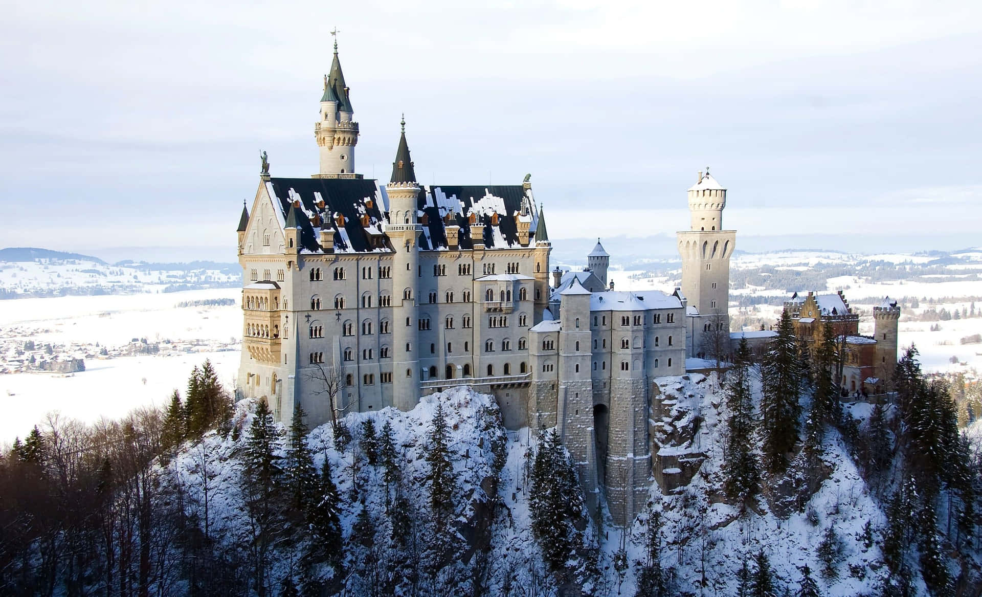 山上的雪城堡，周圍環繞著常青樹和冰凍的山谷。