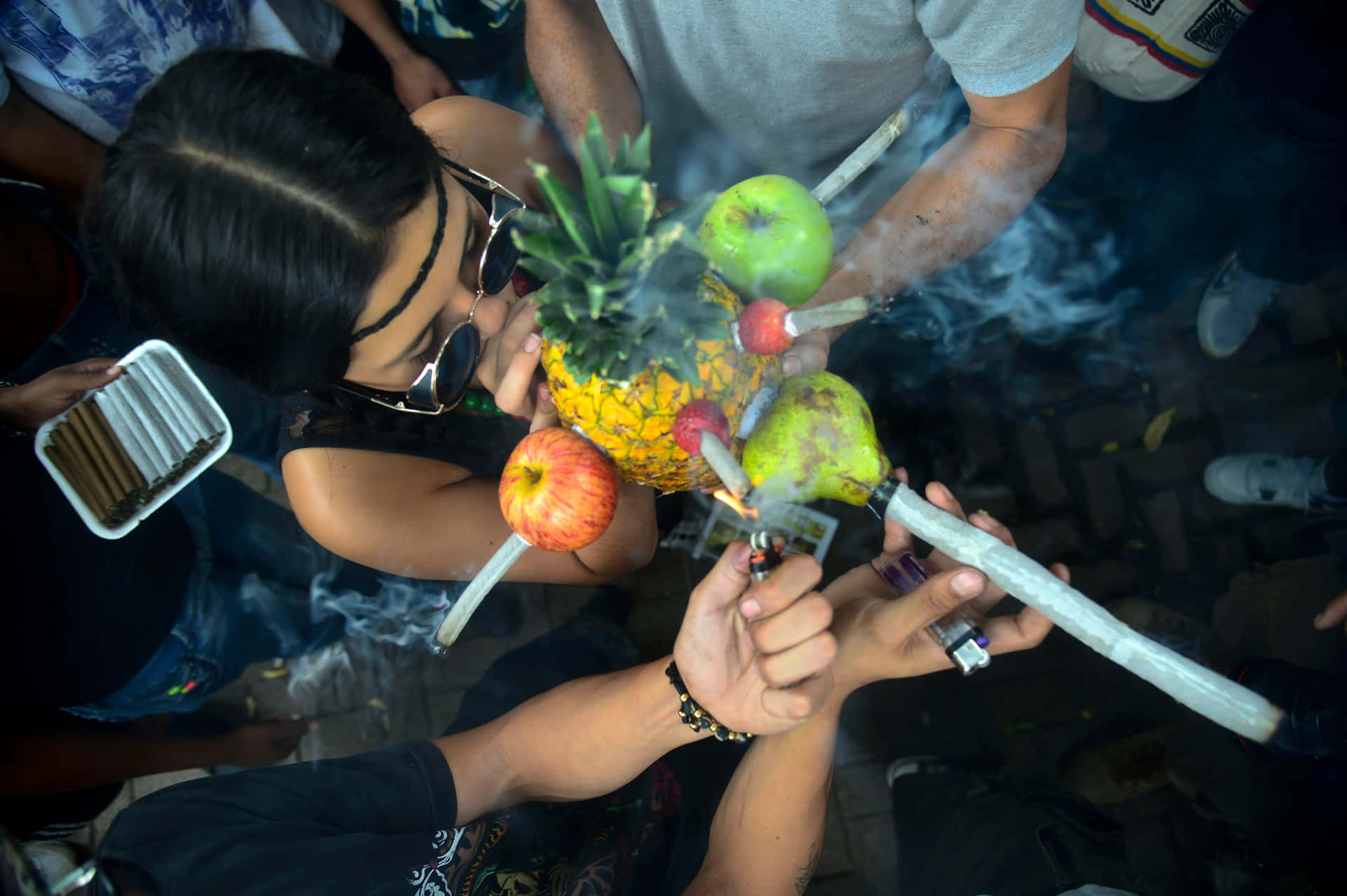 一群人在夜間聚會中點燃水果中的大麻煙。