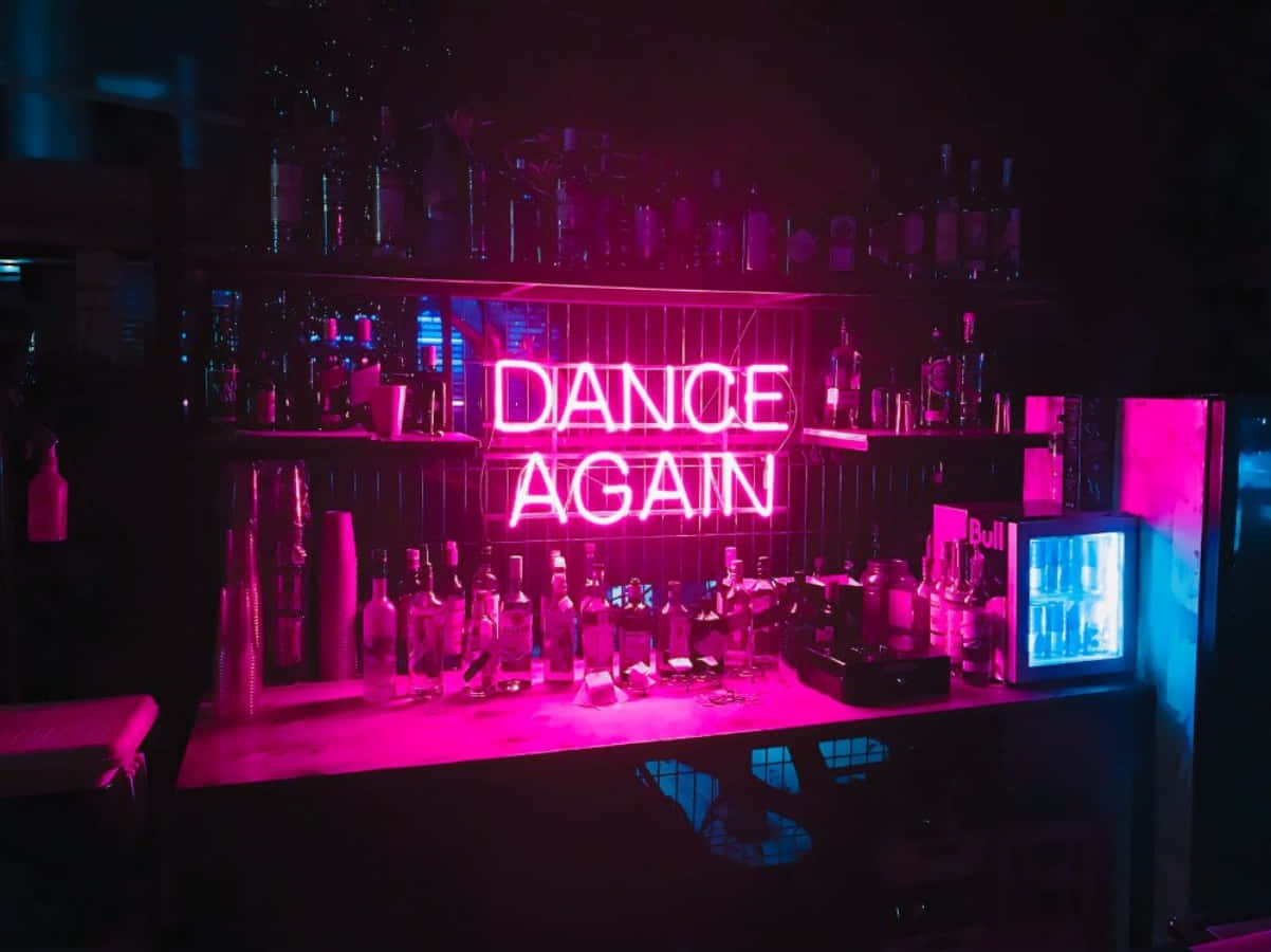 享受夜店的派對音樂 壁紙 — 一個霓虹粉紅色的「DANCE AGAIN」標誌在昏暗的酒吧櫃檯上方發光，櫃檯上擺滿了酒瓶和酒杯，籠罩在充滿情調的紫色燈光下。