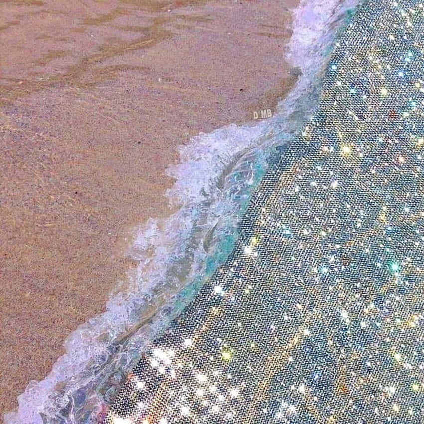 在明亮日光下，海浪在海岸線與閃閃發光的沙灘相遇。