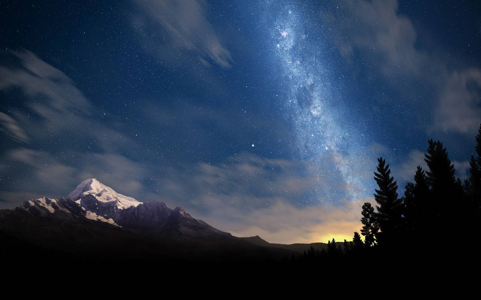在可見銀河的星空下，積雪的山峰。