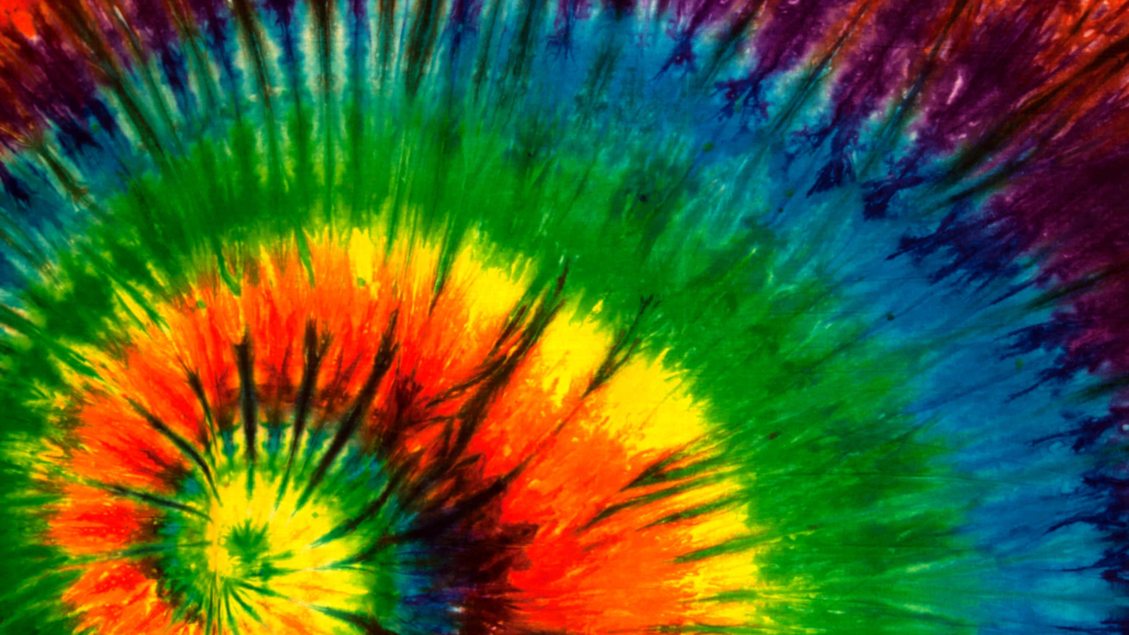 享受扎染的繽紛色彩 壁紙 — 充滿活力的迷幻紮染漩渦從明亮的中心散發出大膽的彩虹色和黑色條紋。