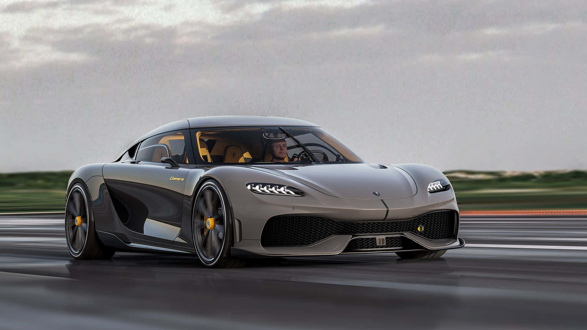 銀色 Koenigsegg Jesko 在潮濕的賽道上飛馳，帶有黃色點綴。