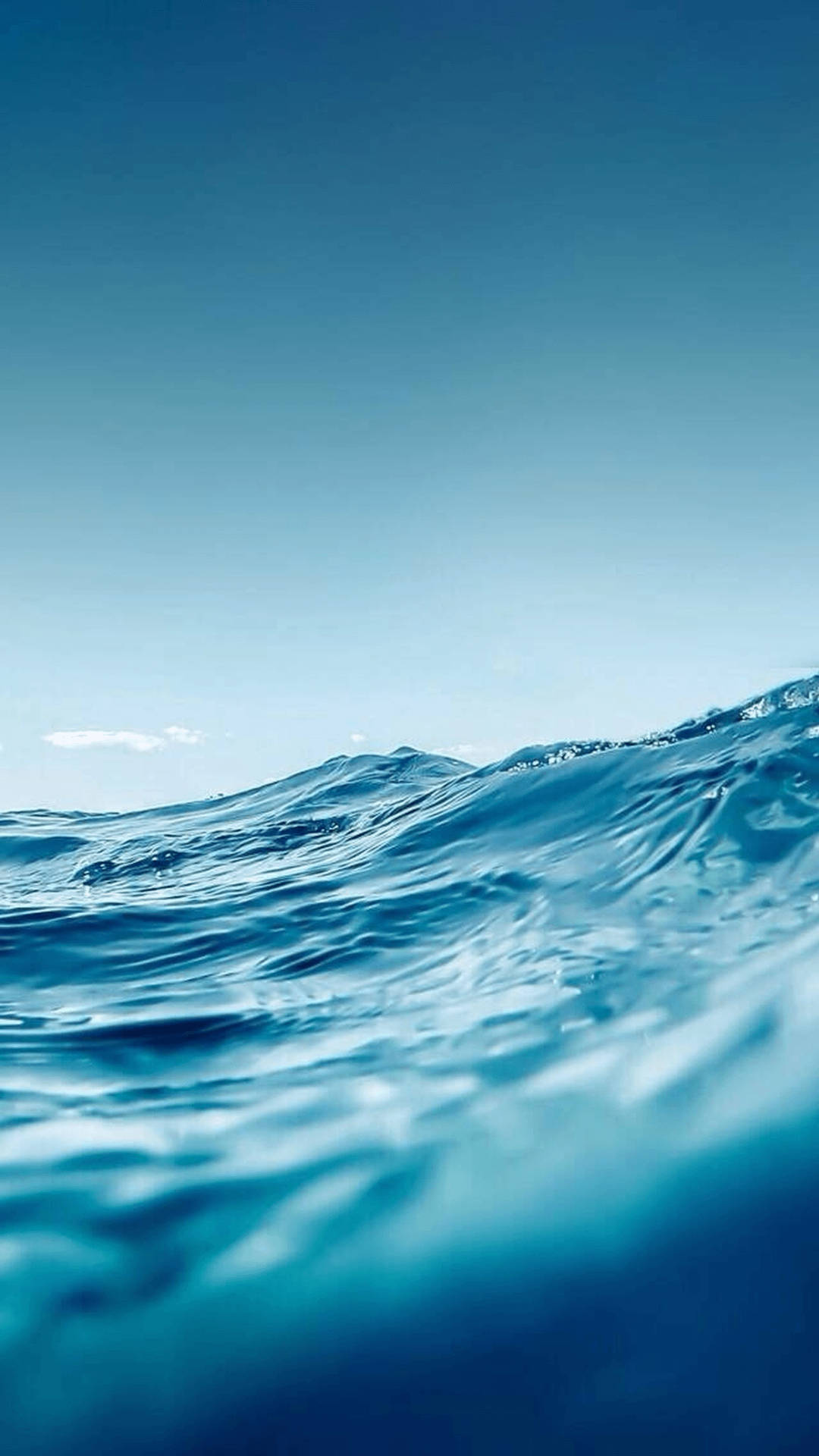 水底視角的海浪，帶有藍色海水和上方清澈天空。