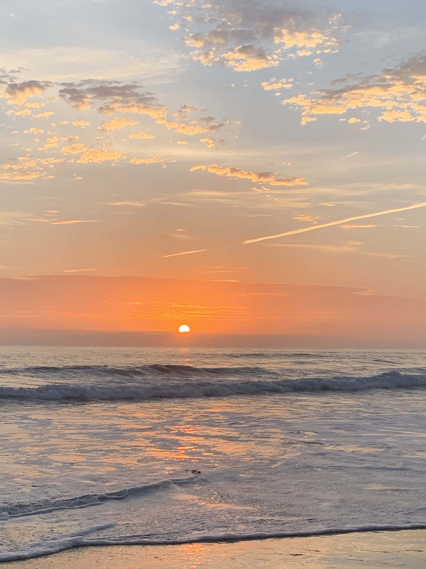 海上日落，海浪和雲朵反射金色光芒。