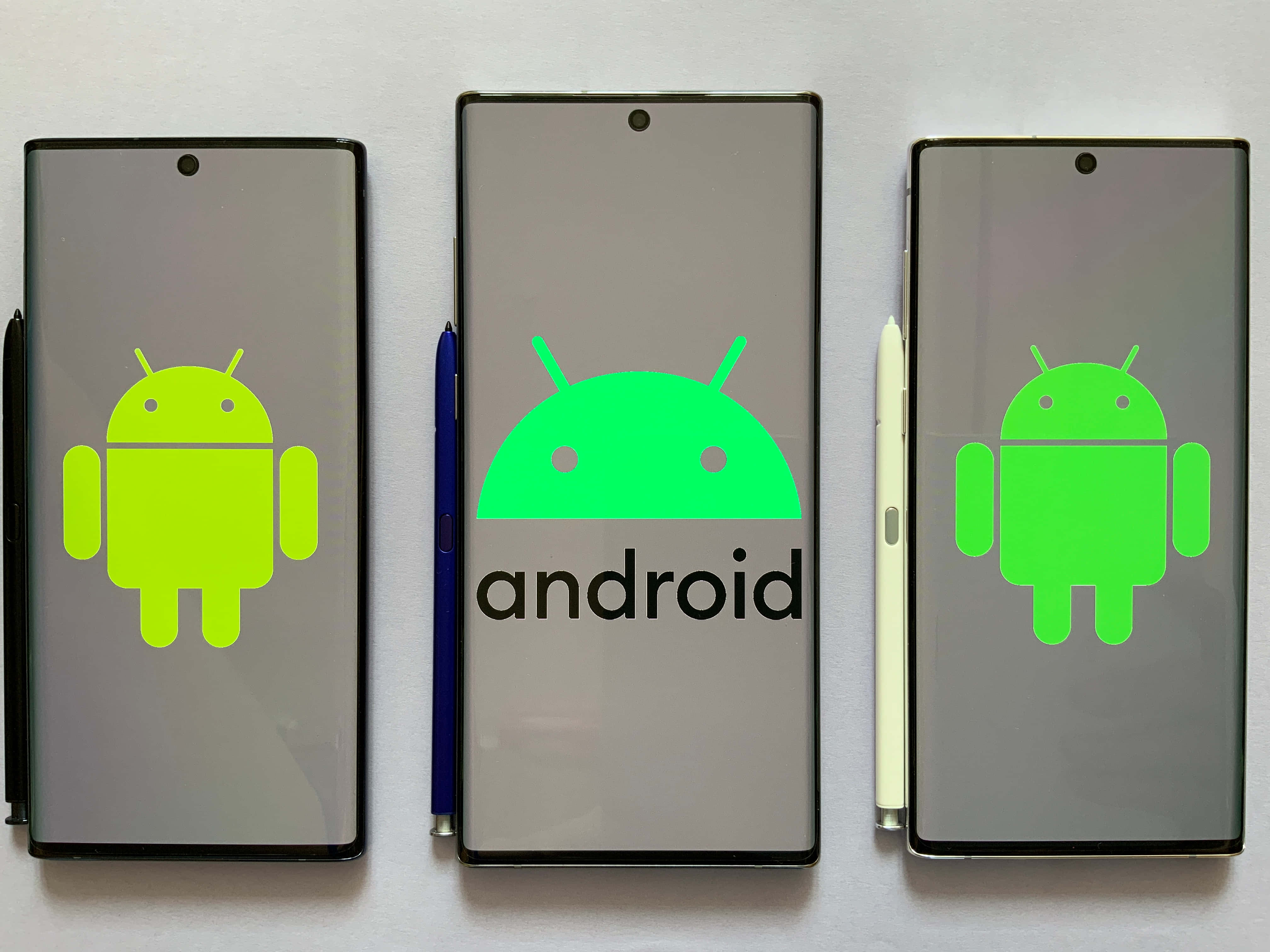 享受獨特且個人化的安卓手機體驗 壁紙 — 三部 Android 智能手機在純白色背景上顯示綠色 Android 標誌和文字商標。