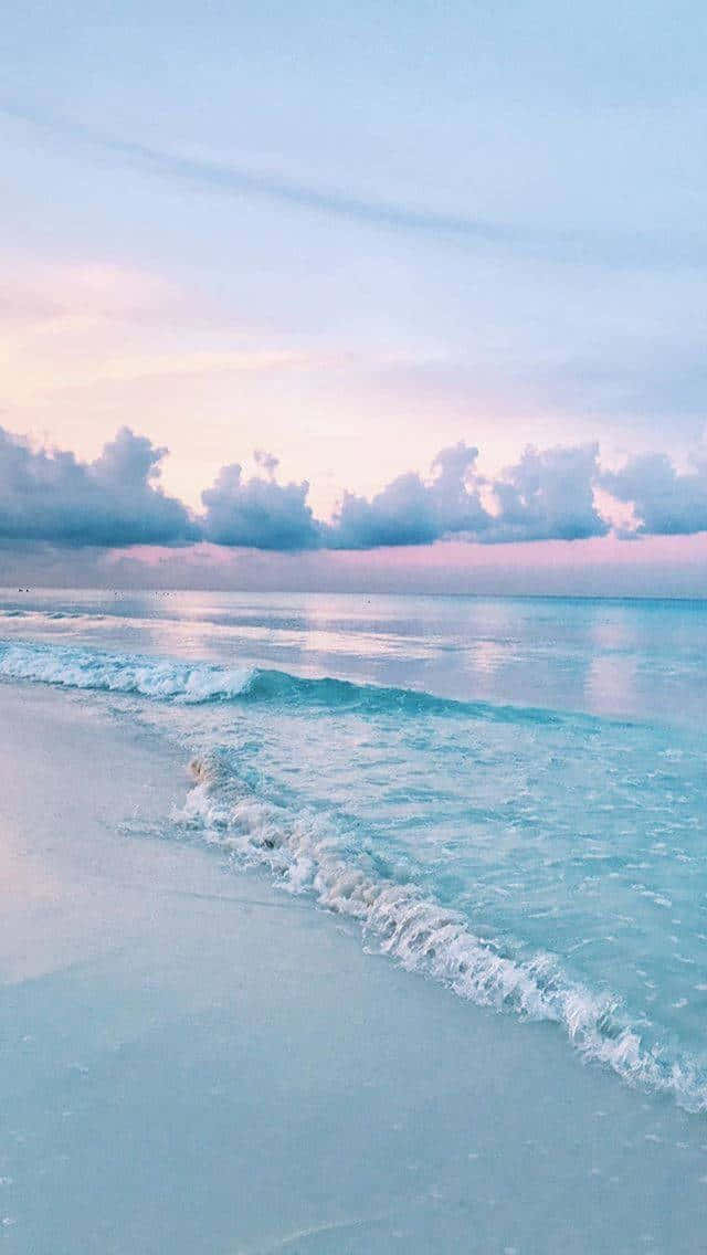 粉彩色的海浪在黃昏時沖刷著沙灘。