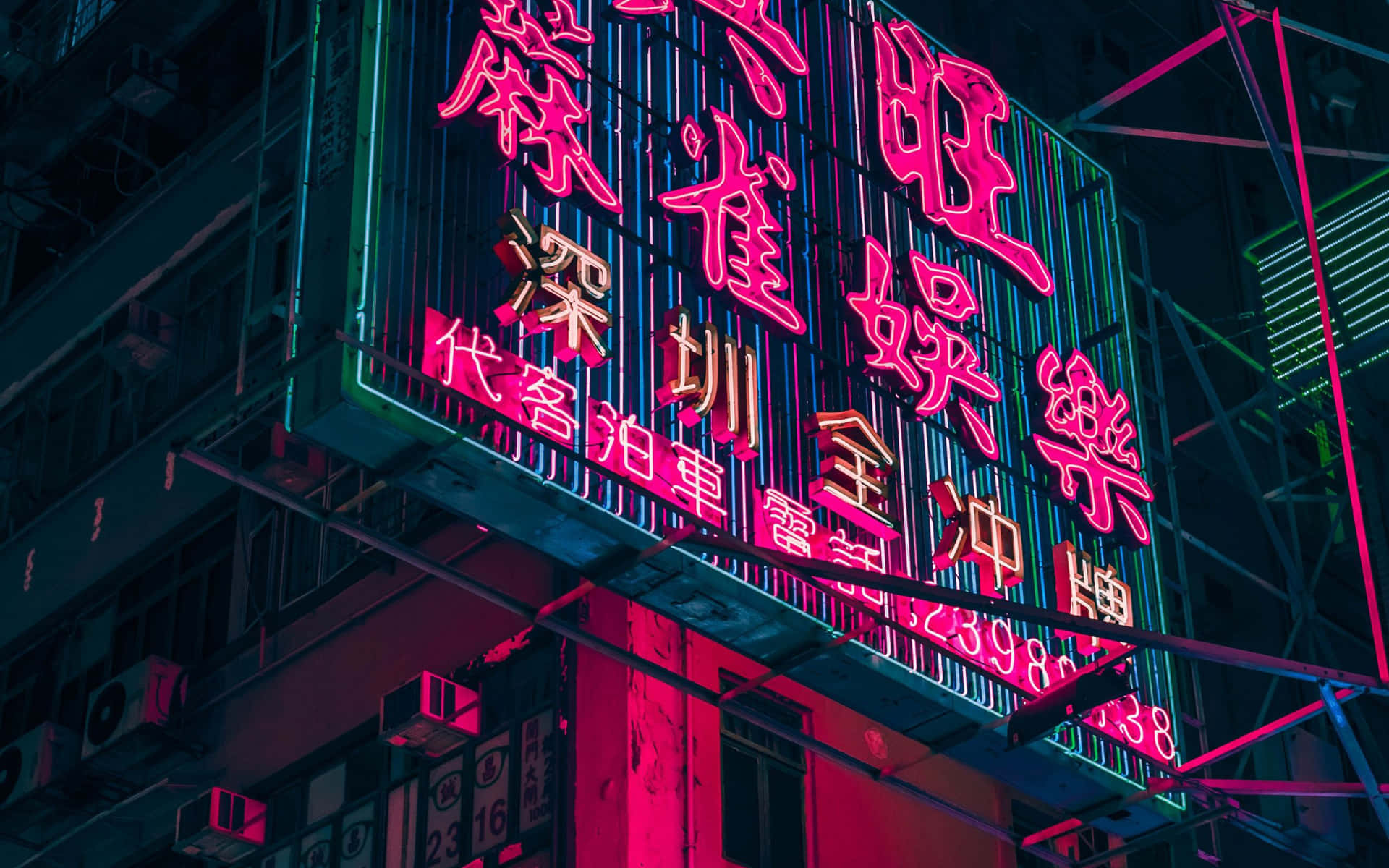 粉紅色和藍綠色的霓虹燈在夜晚照亮城市建築。