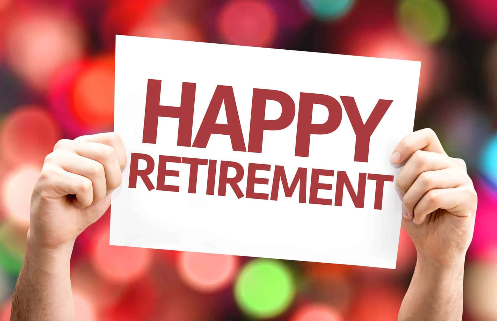 手舉著寫有 happy retirement 的標牌，背景是彩色散景。
