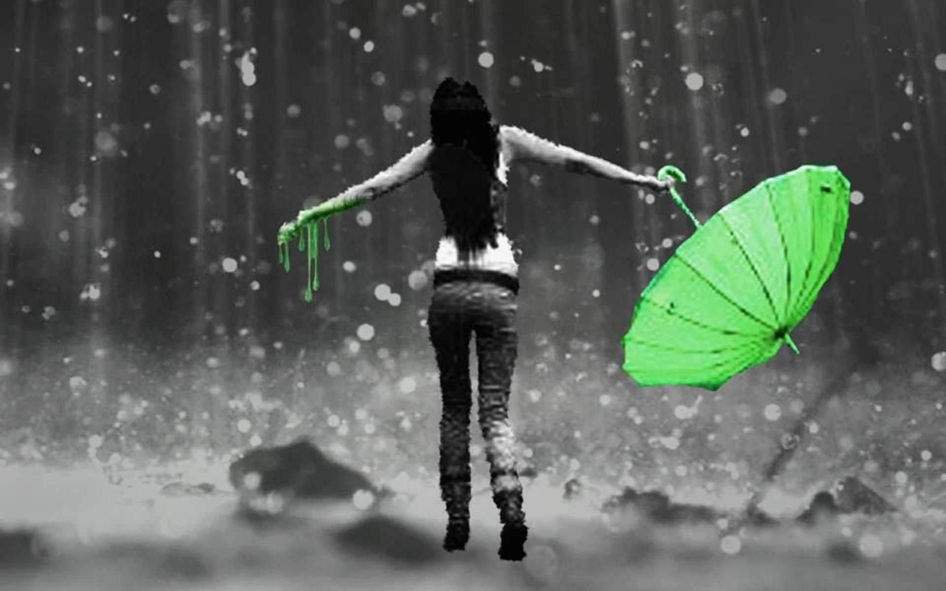 喺大雨中張開雙臂舉起綠色遮嘅人。