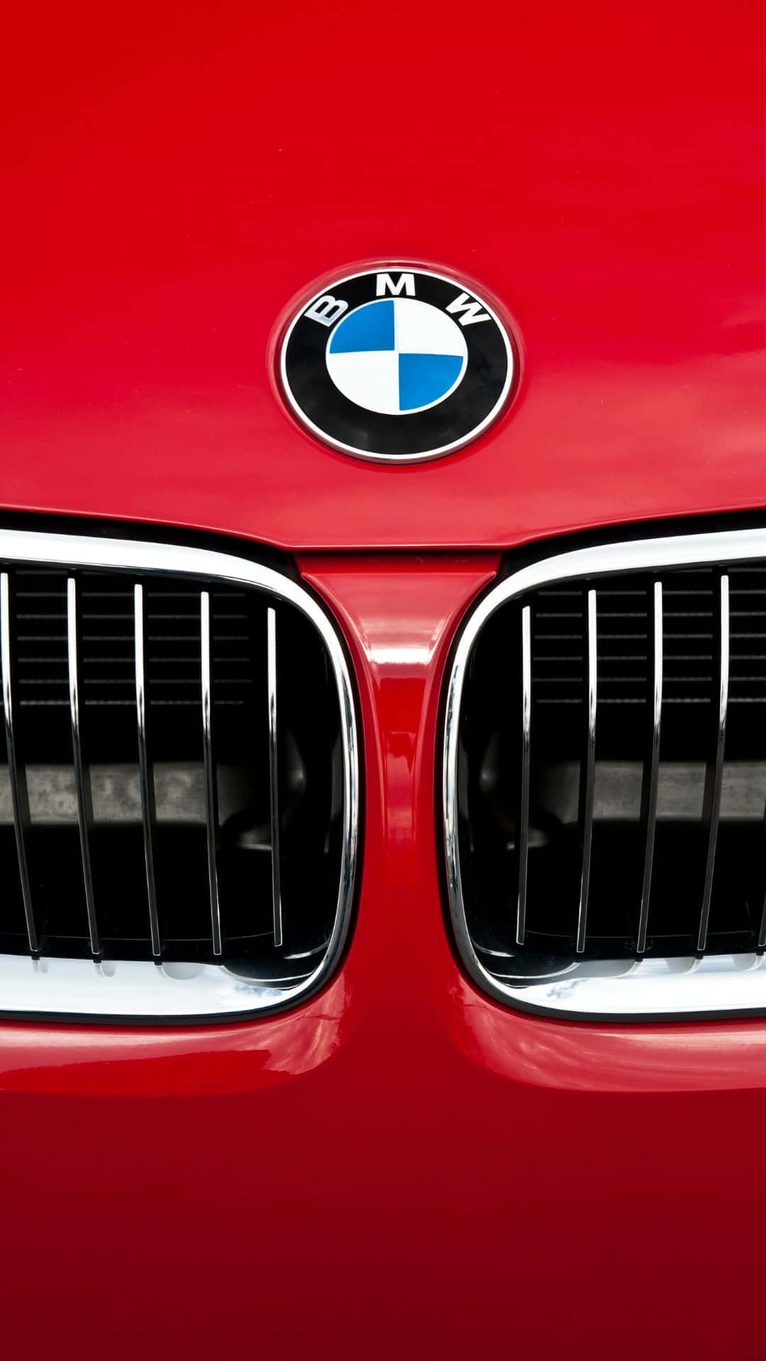 享受高技術BMW體驗，配備安卓系統 壁紙 — 鮮紅色寶馬汽車標誌性腎形格柵和圓形標誌的特寫，表面光滑。