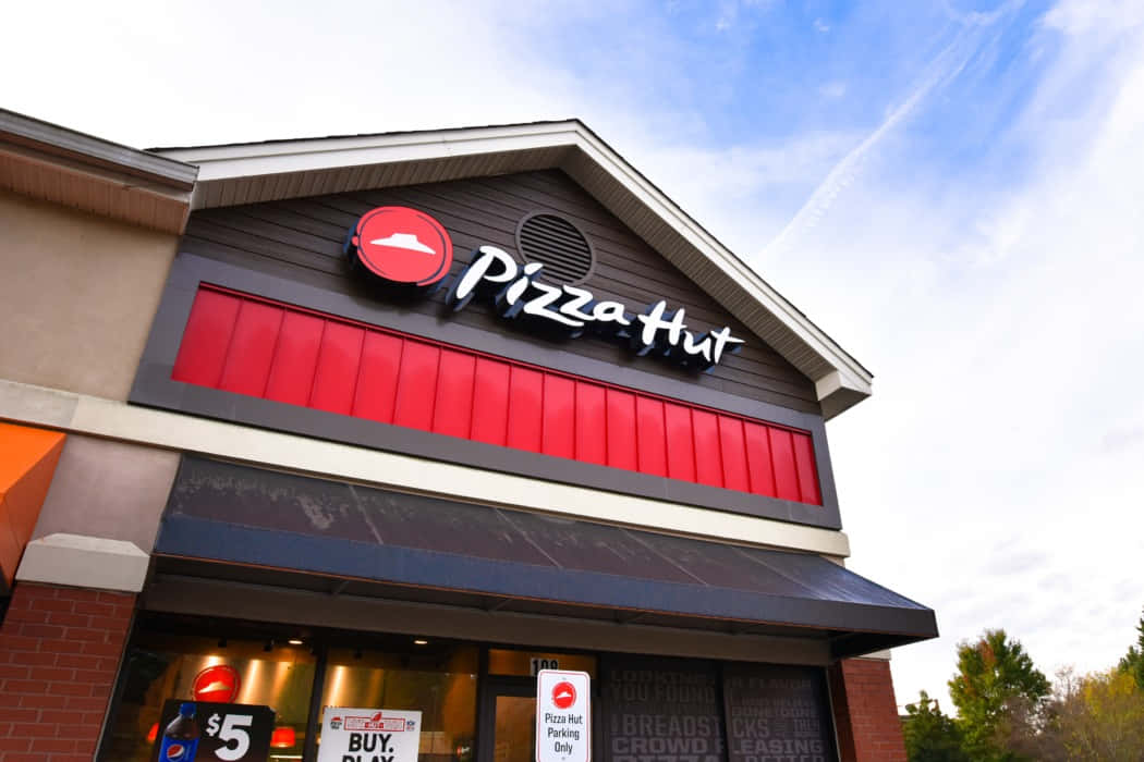 Pizza Hut餐廳外部，帶有紅色招牌和秋樹