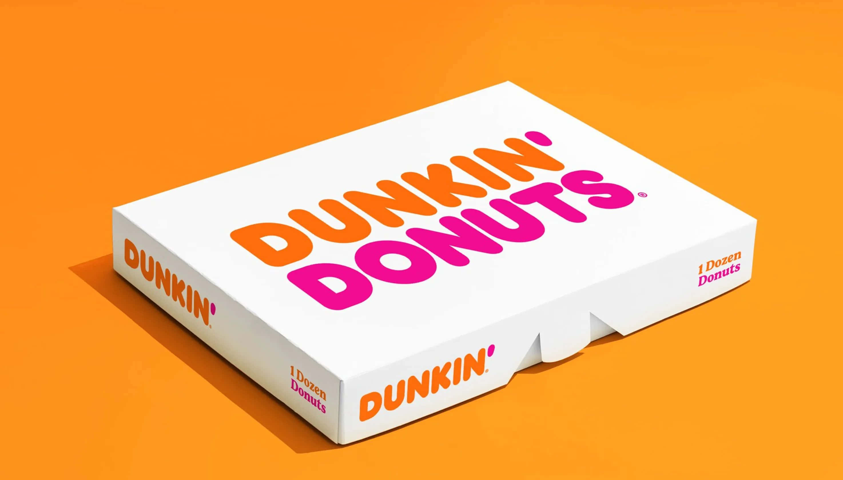 享用經典冰咖啡，Dunkin' Donuts 壁紙 — 一個白色Dunkin' Donuts盒，帶有醒目的橙色和粉紅色標誌，傾斜放置在充滿活力的橙色背景上。
