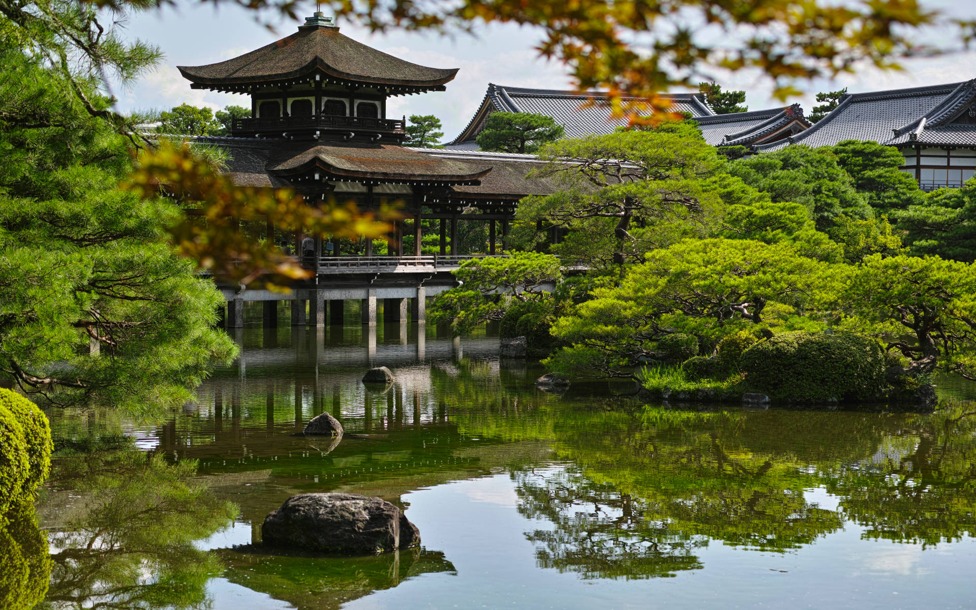 傳統日本庭園，亭閣與水面倒影被綠樹環繞。