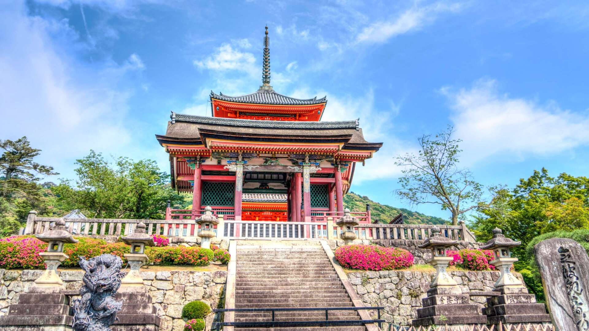 紅色日本寺廟，石階和粉紅色花朵，藍天