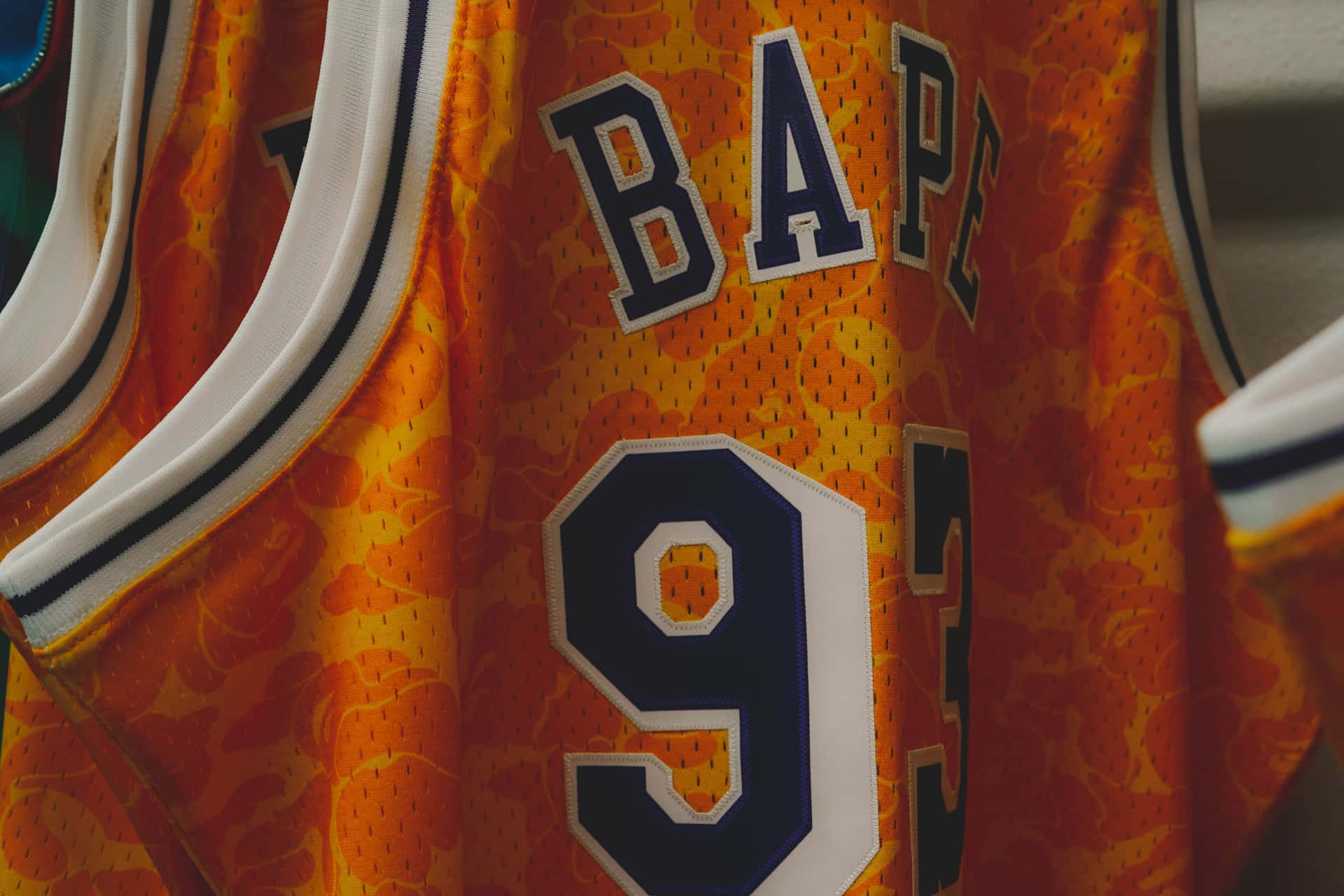 橙色 BAPE 籃球球衣特寫，數字 93。