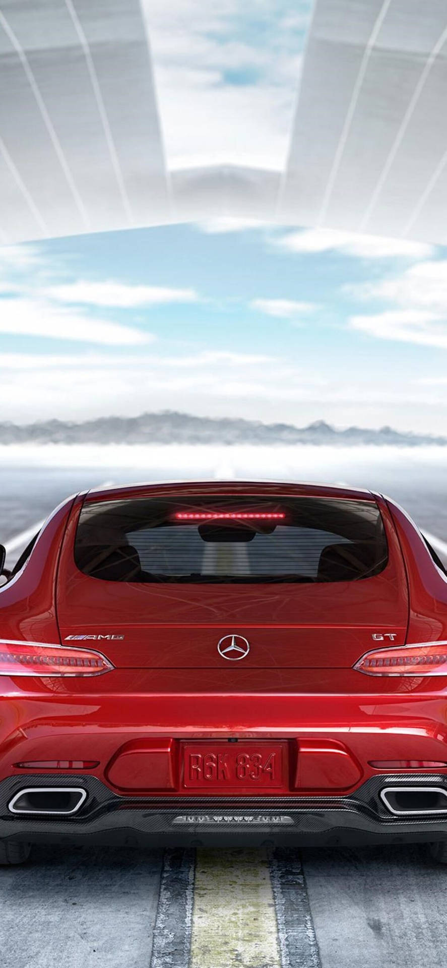 紅色 Mercedes-AMG GT 跑車在玻璃天篷下的道路上，有山脈和天空。