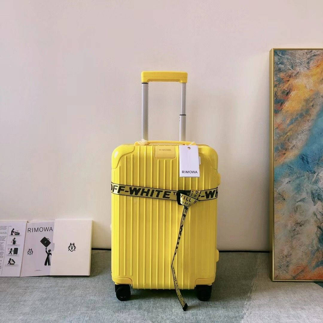 黃色RIMOWA行李箱配OFF-WHITE帶子，現代房間內有藝術品和品牌盒子。
