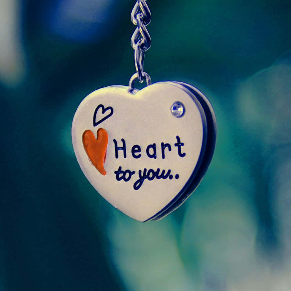 銀色心形吊飾，刻有「Heart to you.」和一個橙色心形。