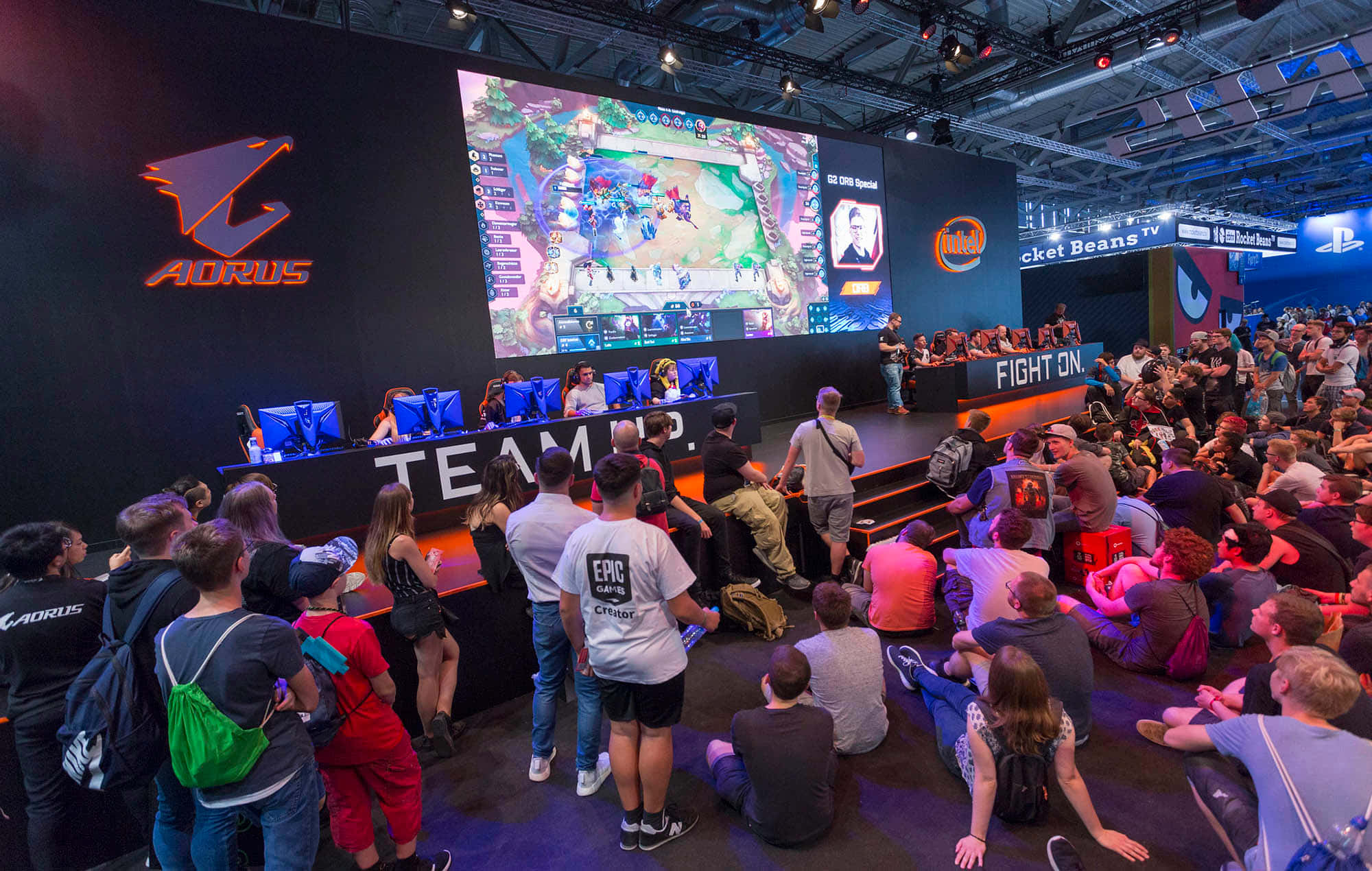 Gaming Conventions 桌布 壁紙 — 人群在遊戲展覽會上觀看電競選手在明亮燈光下的舞台上比賽。