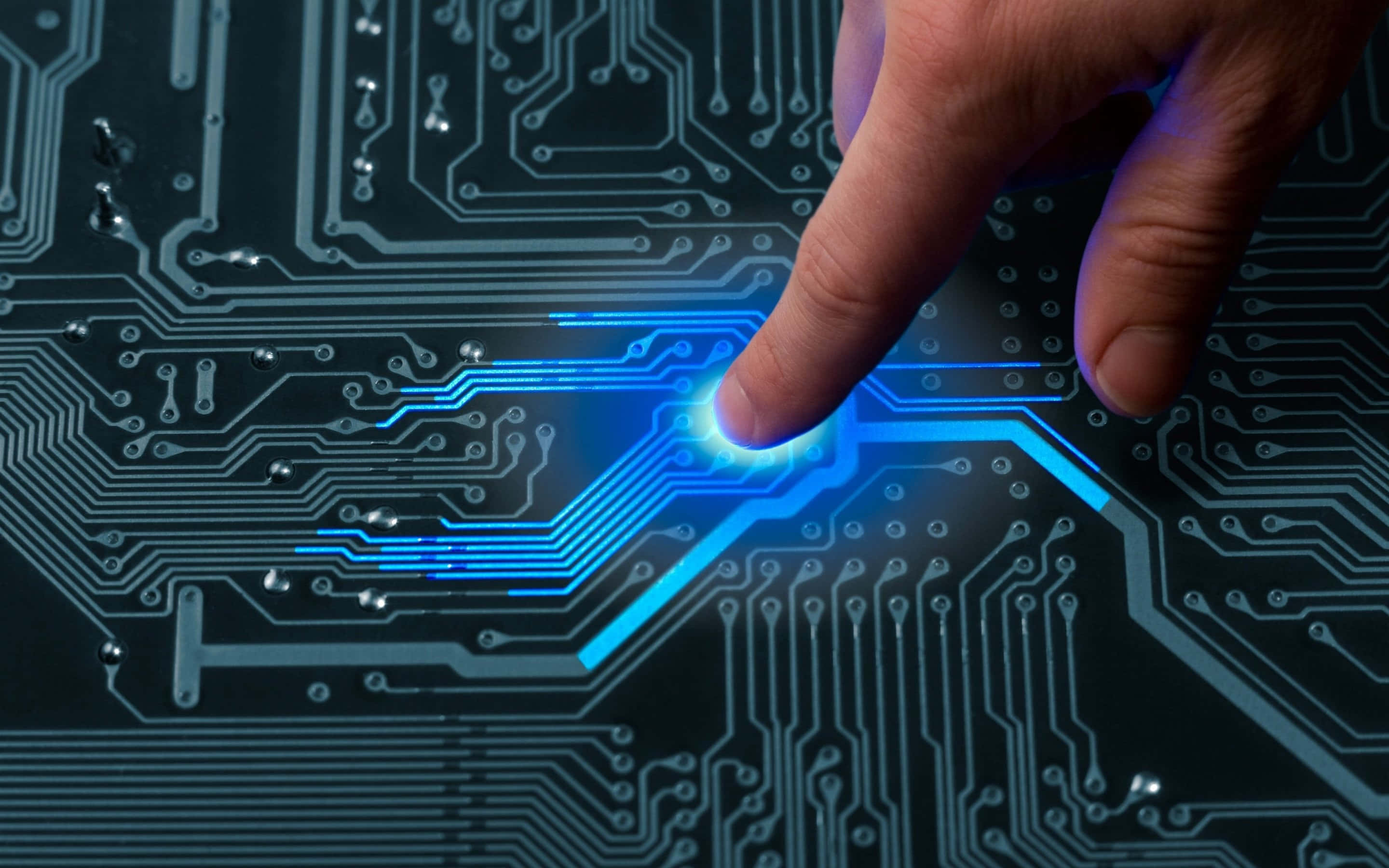 Electronics 桌布 壁紙 — 人類手指觸碰發光藍色電路板，觸發數碼光效。