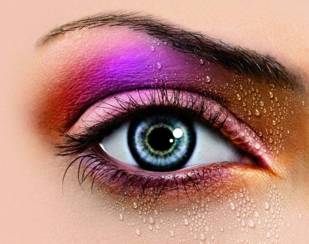 Purple Eye Shadow 桌布 壁紙 — 人類眼睛嘅特寫，帶有充滿活力嘅紫色同橙色眼影，以及喺眼瞼同皮膚上閃閃發光嘅水滴。