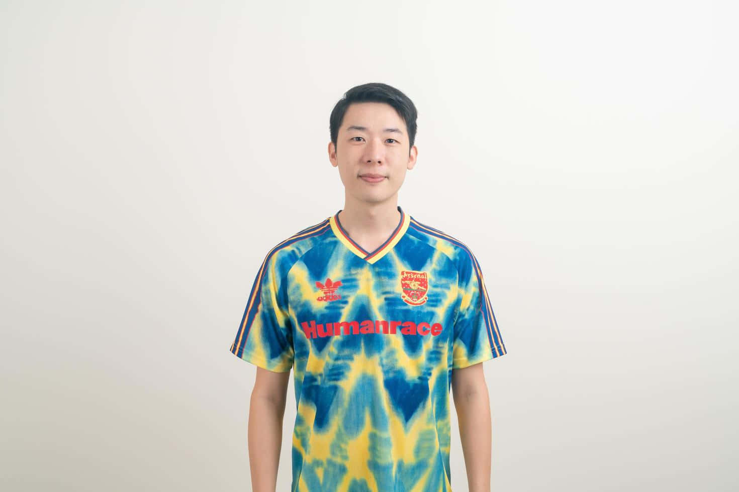 年輕男子身穿藍黃紮染足球球衣，帶紅色文字