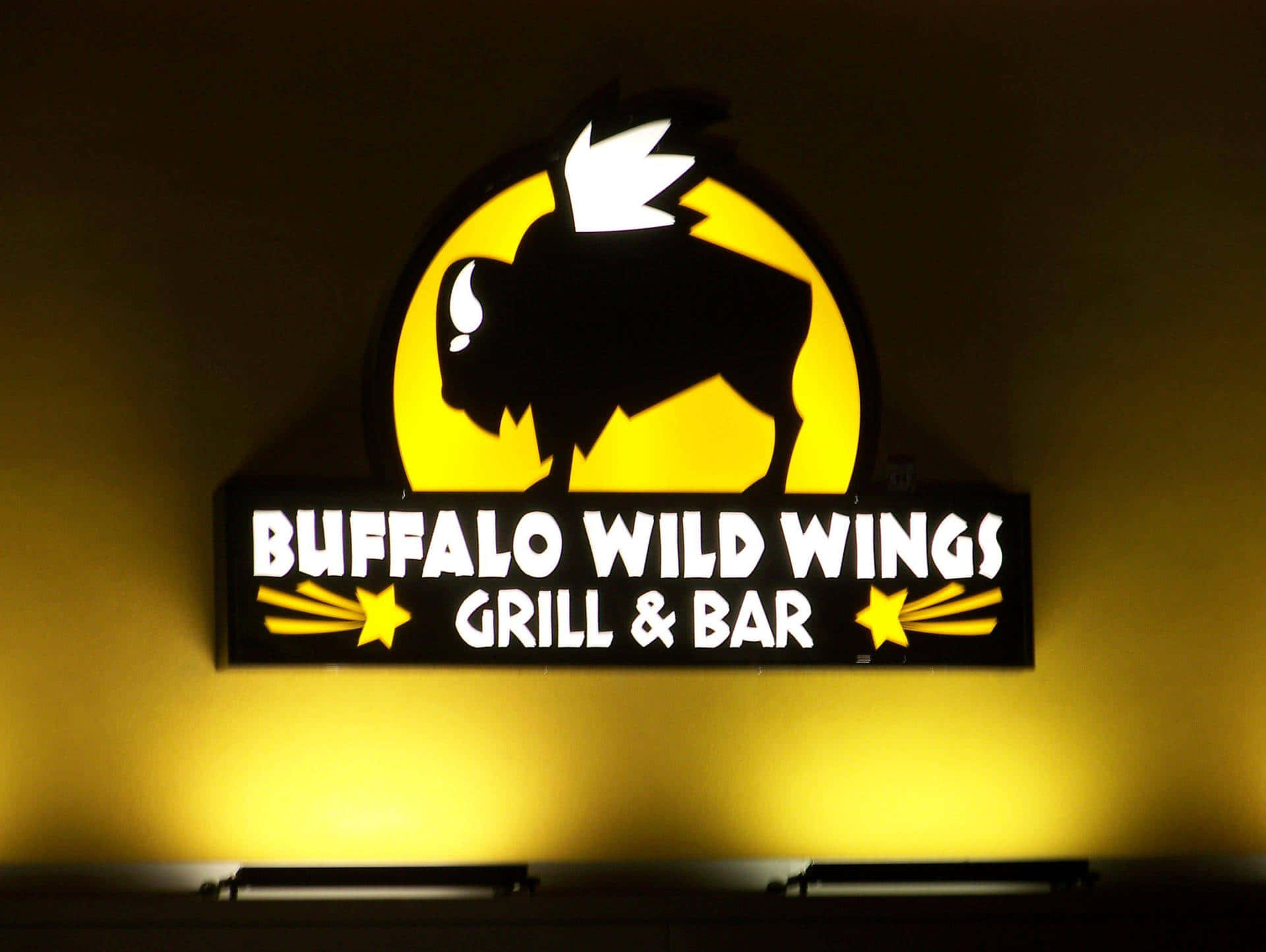 Buffalo Wild Wings 餐廳標誌在夜間牆上發出黃光。