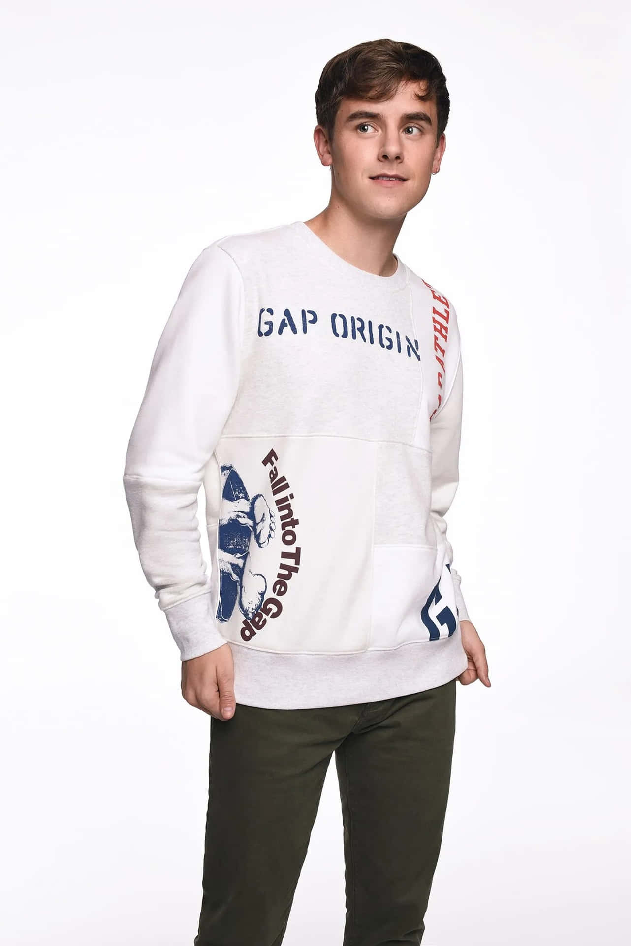 年輕男子在攝影棚內穿著白色Gap Origin衛衣和橄欖色長褲。
