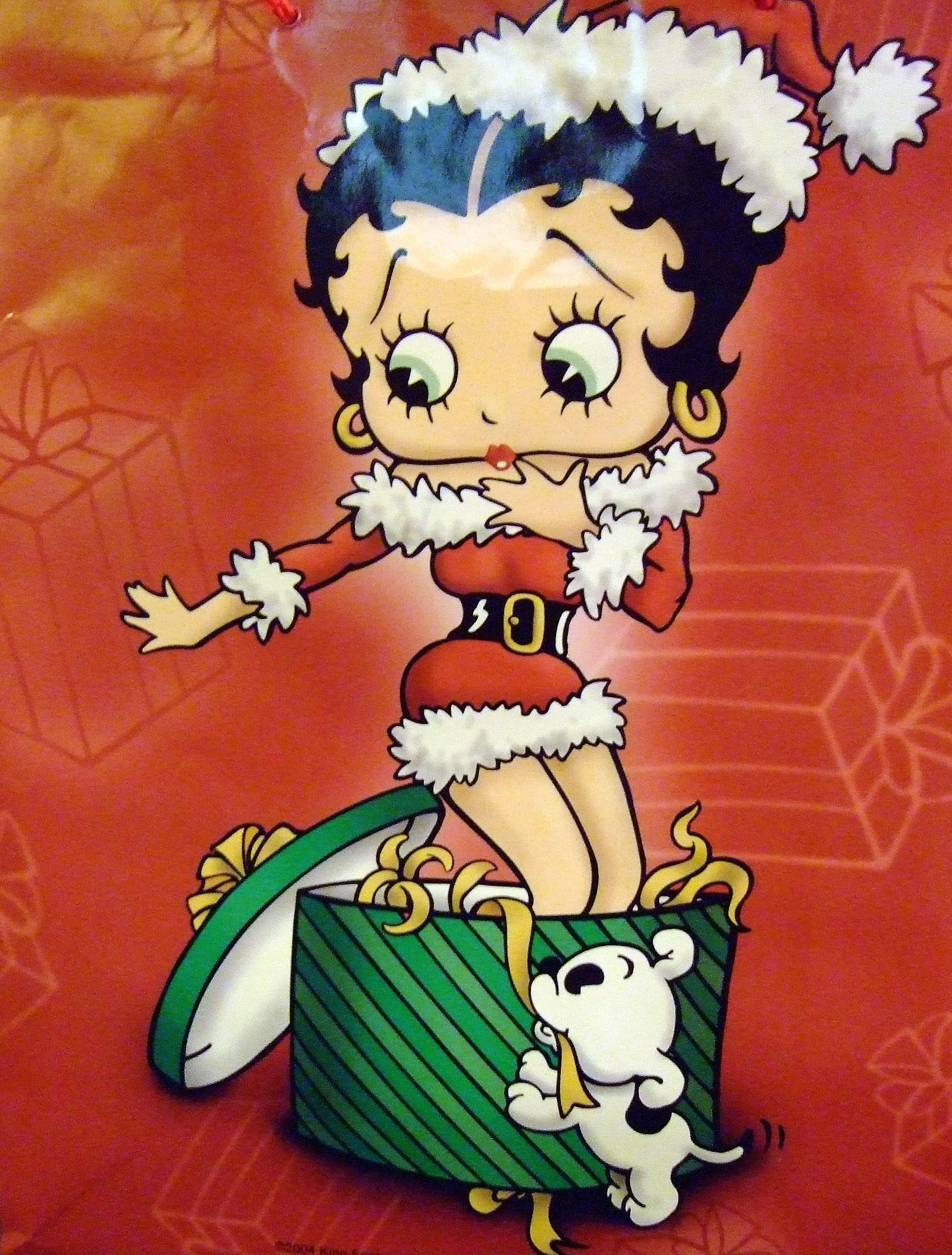 「今天是展現勇氣的日子！」 壁紙 — Betty Boop 穿著節日聖誕老人服裝，從綠色條紋禮物盒中出現，旁邊有一隻白色小狗，背景為紅色。
