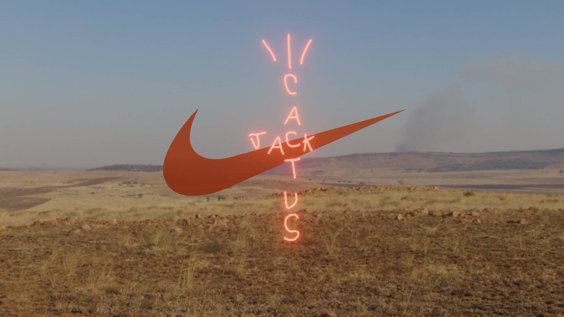 霓虹Nike剔號和Cactus Jack標誌在乾燥的草地上發光。