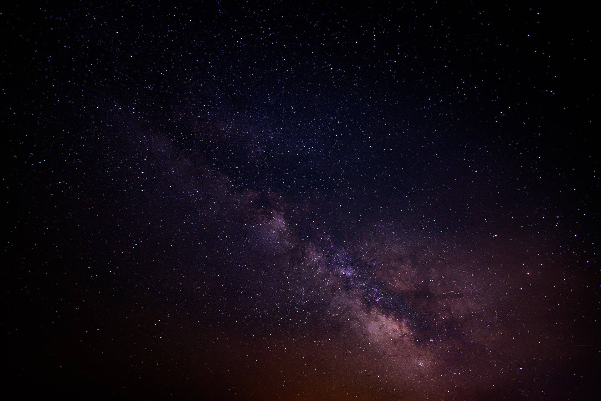 銀河系在黑暗的夜空中閃耀著紫色和粉紅色的星星。