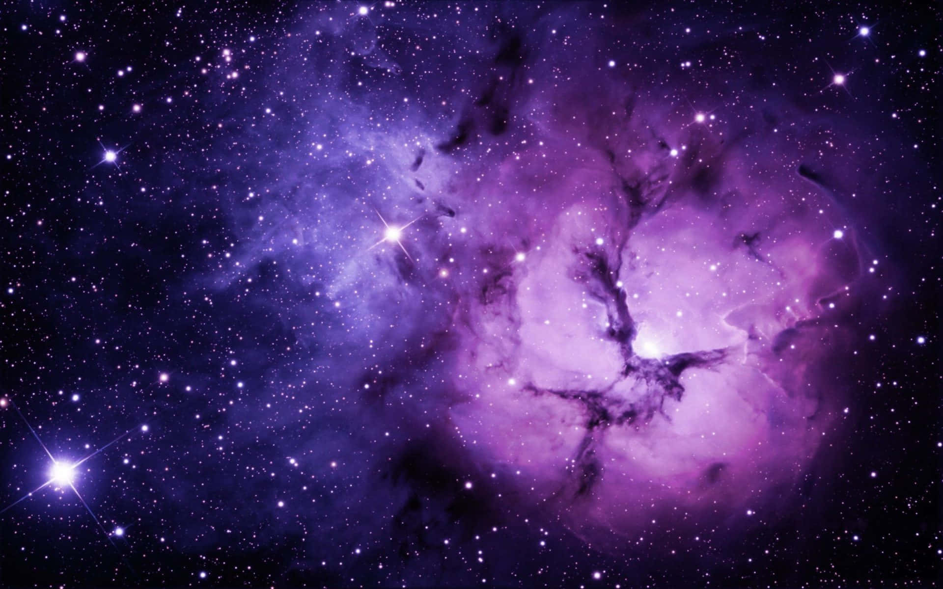 Purple Galaxy 桌布 壁紙 — 令人嘆為觀止的景色，一個充滿活力的紫色星雲在深邃的宇宙背景下閃爍著星星。