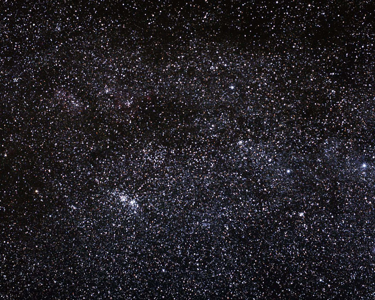 Dark Sky 桌布 壁紙 — 令人嘆為觀止的銀河系景觀，充滿了無數閃爍的星星和宇宙塵埃雲，映襯著深邃的黑色天空。