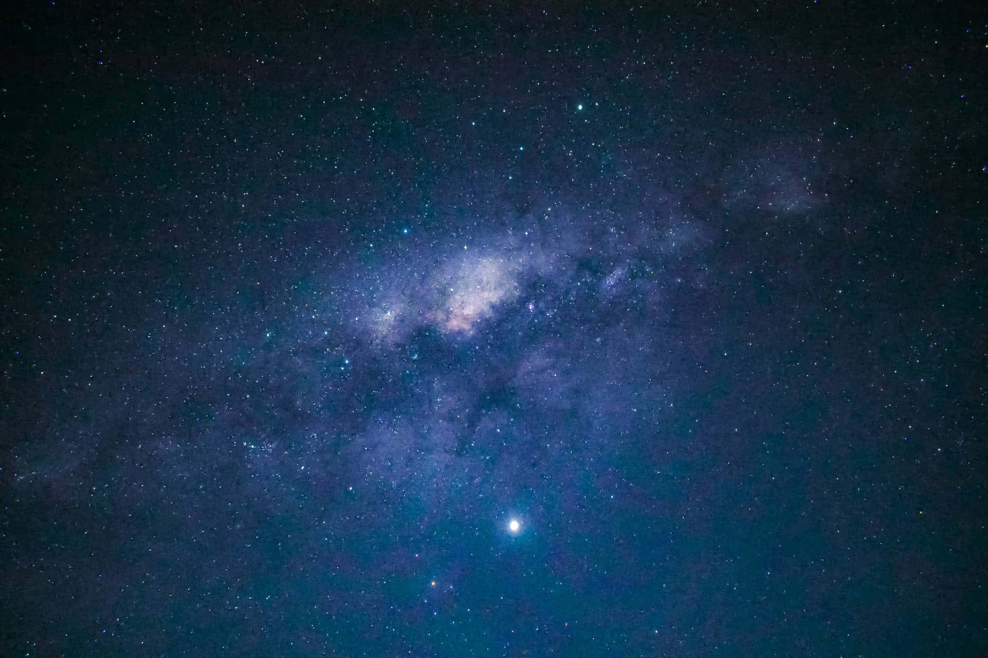 星空 桌布 壁紙 — 令人嘆為觀止的銀河系景觀，在繁星點點的夜空中散發著紫色和藍色的光芒。