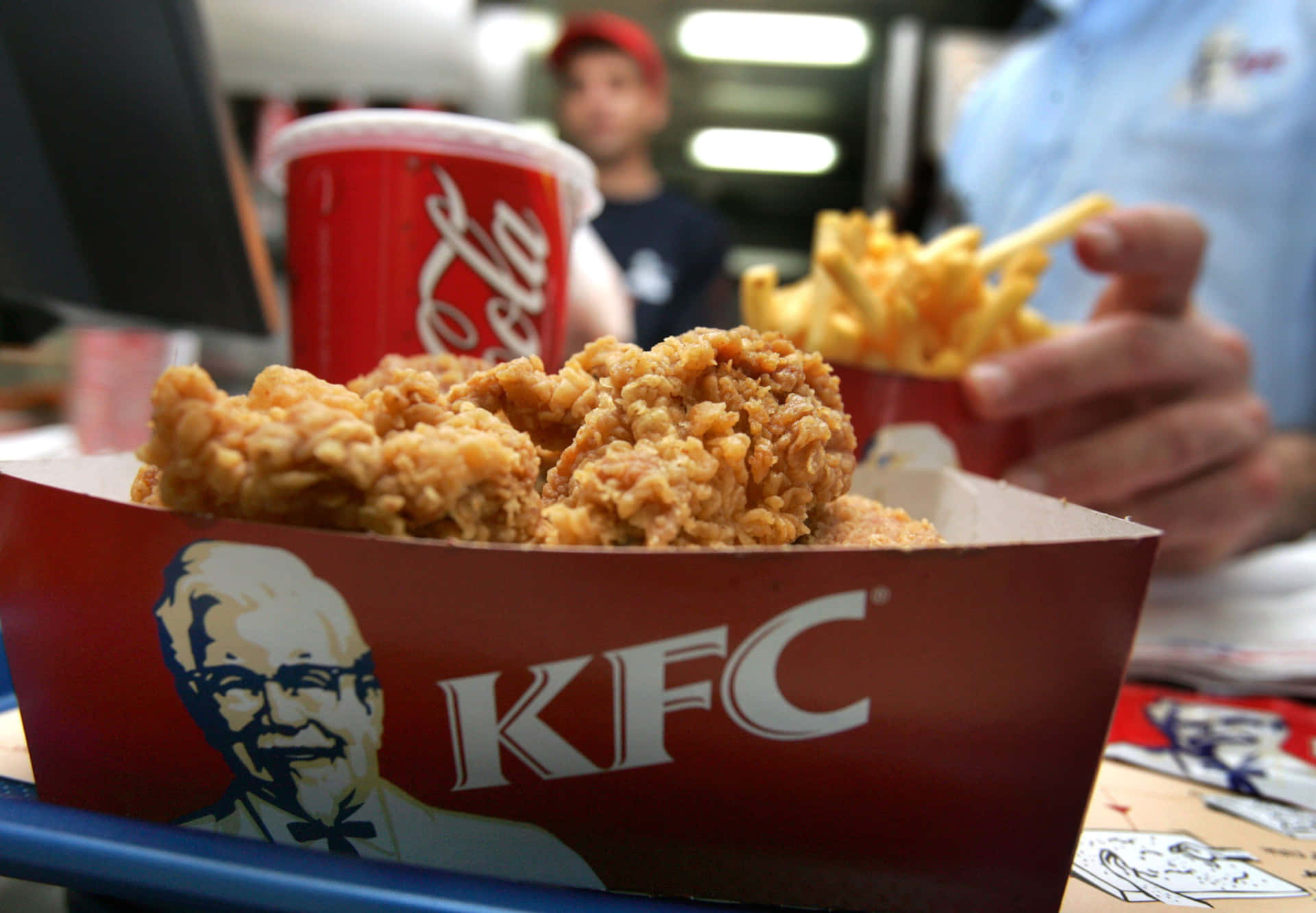 餐廳內KFC炸雞和薯條配可口可樂杯的特寫。
