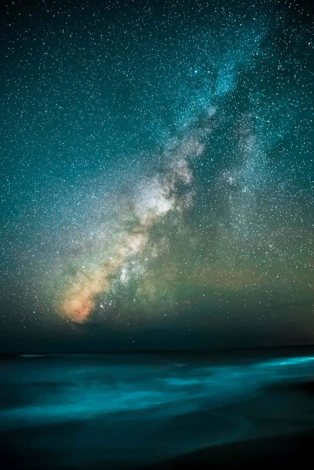 夜晚發光海洋上空的銀河系