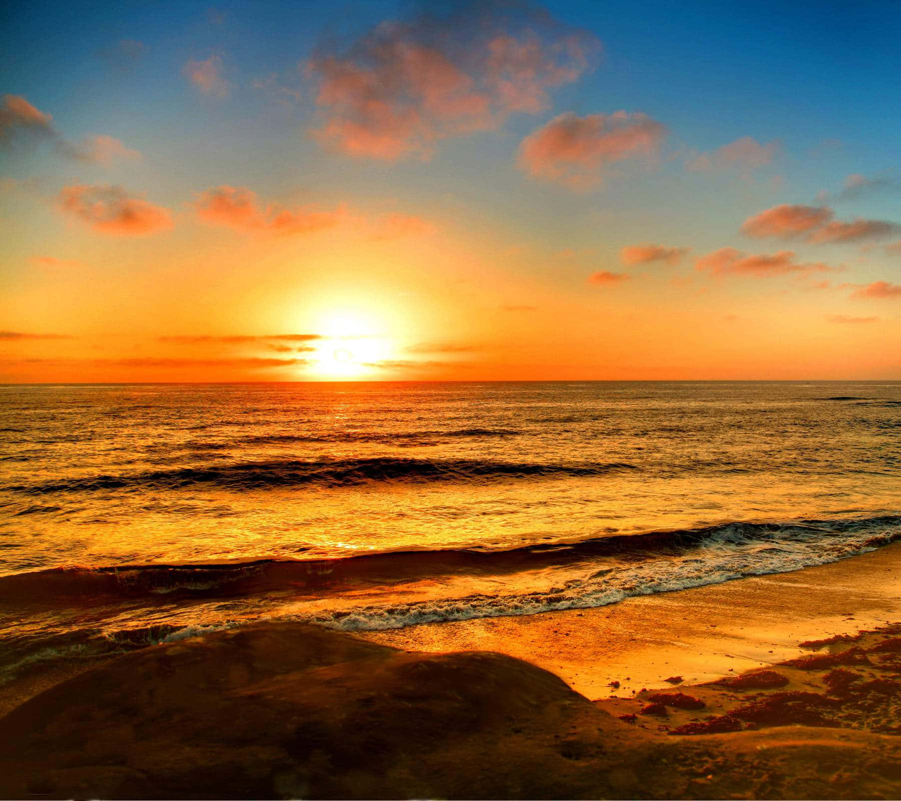 夕陽下的海洋，沙灘上的海浪，色彩繽紛的天空