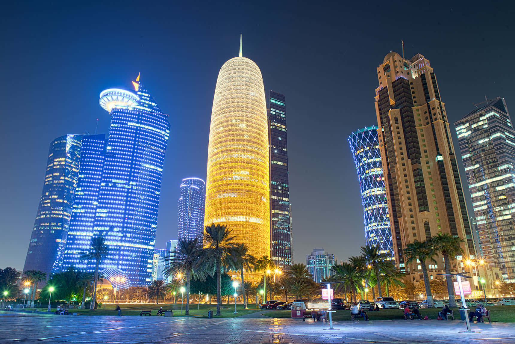 Qatar 桌布 壁紙 — 令人眼花繚亂的現代摩天大樓夜景，在黑暗的天空中閃爍著藍色和金色的光芒。
